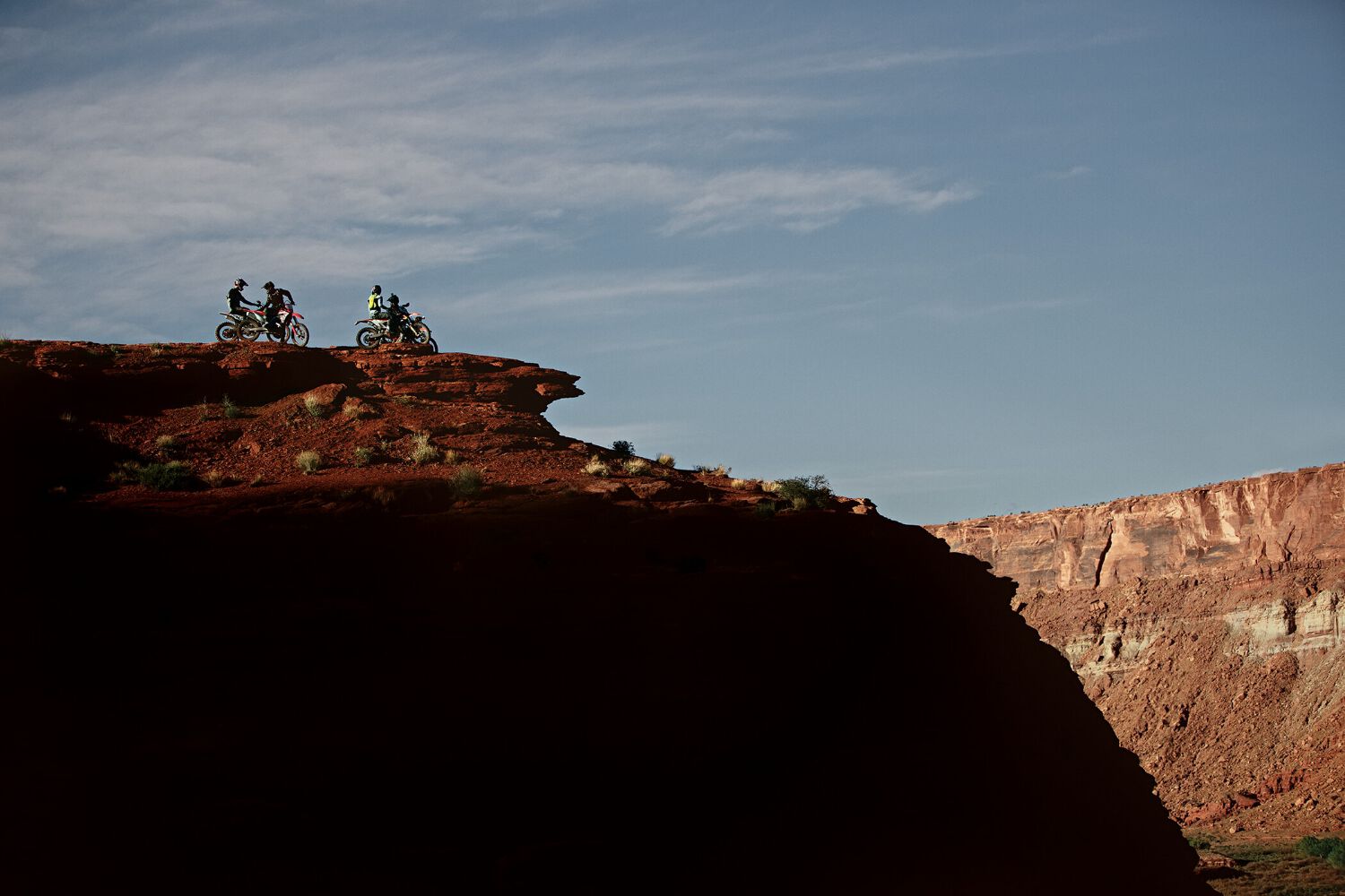 A group of enduro riders stopped on cliff's edge.